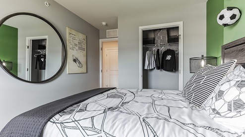 Second bedroom upstairs soccer themed with view of the closet.