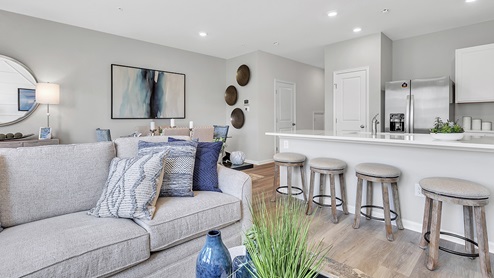 Part of the living and kitchen counter area with seating. Dining area in the back left.