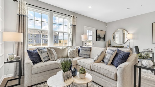 Living area with the large window and back door with dining area in the back left.