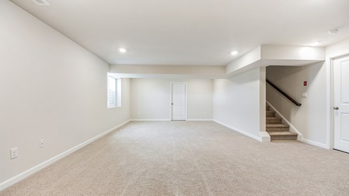 Different view of the downstairs area with stairs visible.