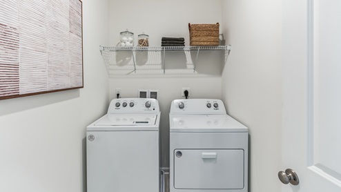 Laundry room with washer and dryer and shelf above.