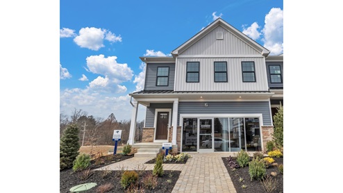Exterior front image of the model townhome with gray and horizontal paneling and white vertical paneling with a white two car garage.