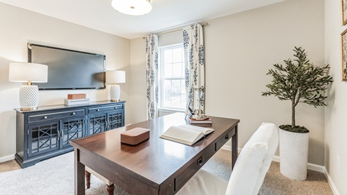 Bedroom four is decorated as an office space with view of a single window.