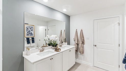 Second floor bathroom two with white counter top and double sink vanity.