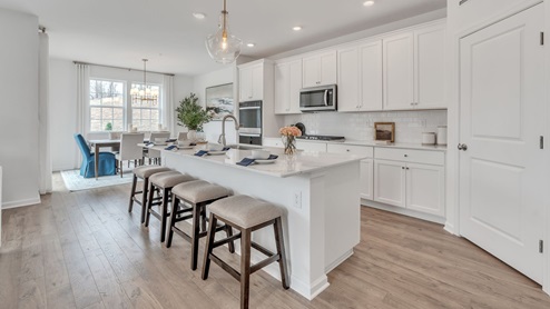 Kitchen area with pantry to the right and dining area in the back left corner.