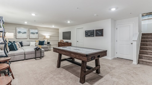 Basement rec room perfect for entertaining with stairs visible.