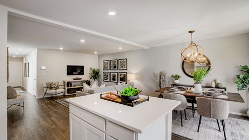 Kitchen with shaker cabinets, quartz counters, stainless steel appliances, pantry, and an island with a breakfast bar