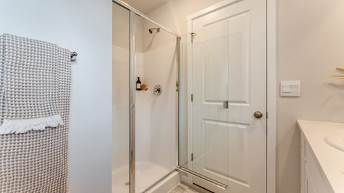 primary bathroom with a walk-in shower, white quartz countertops, and a large vanity