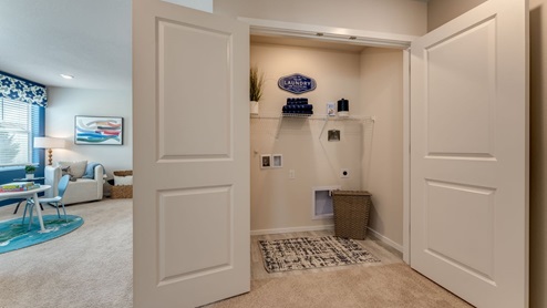 laundry closet with white wire shelves, and premium laminate flooring