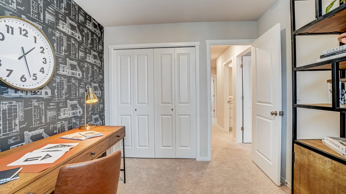 Bedroom staged as an office with wall-to-wall carpet and a closet