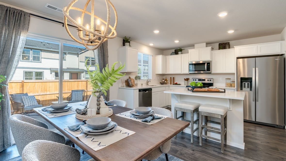 Kitchen with shaker cabinets, quartz counters, stainless steel appliances, pantry, and an island with a breakfast bar