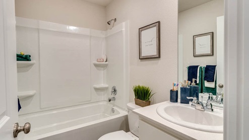 bathroom with quartz countertops, combination show/bathtub, and white toilet