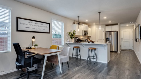 u-shaped kitchen with stainless steel appliances, quartz countertops, and a full size pantry