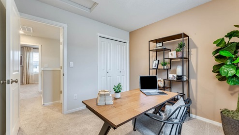 third bedroom staged as a home office with wall-to-wall carpet