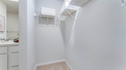 primary bedroom walk in closet with wire shelves
