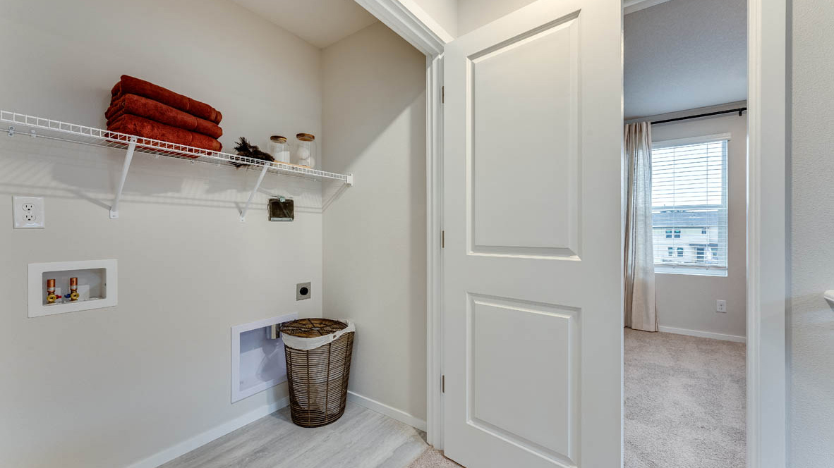 Laundry closet with wire shelves and washer and dryer hookups