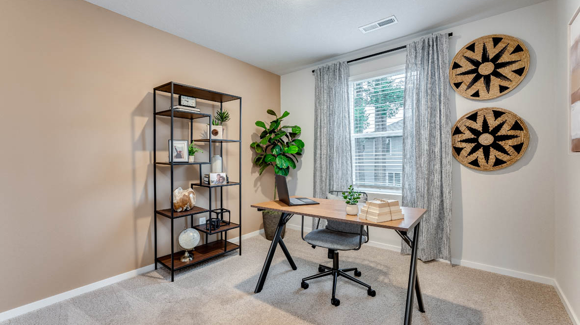 Bedroom staged as an office with wall-to-wall carpet and a closet