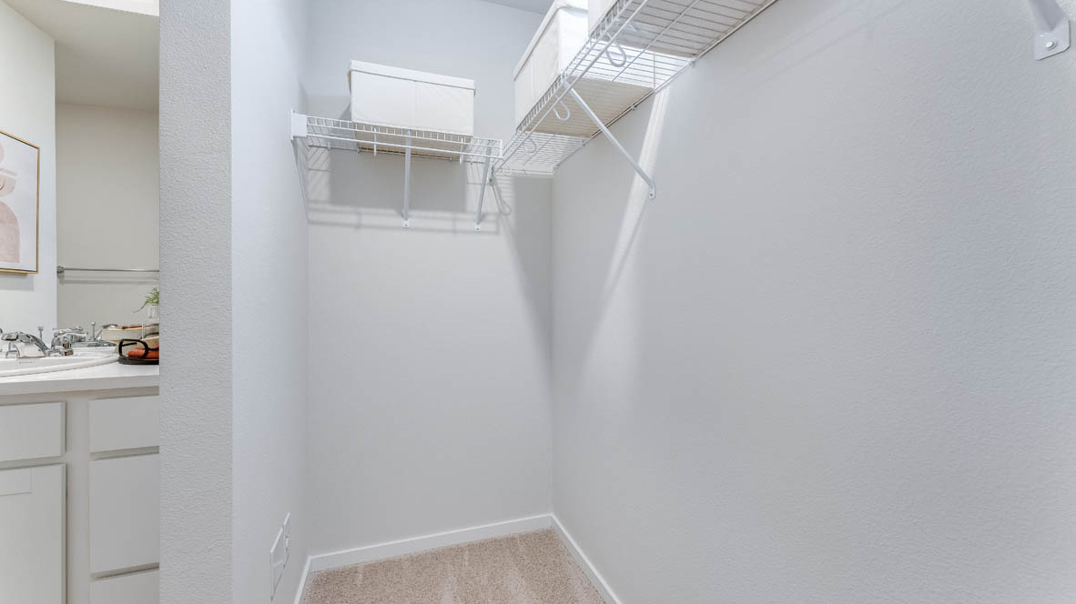 Primary bedroom walk-in closet with wire shelves