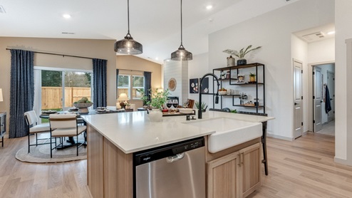 Kitchen with shaker cabinets, quartz counters, stainless steel appliances, pantry, and an island with a breakfast bar