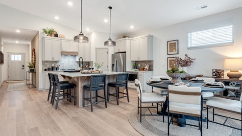 Kitchen with shaker cabinets, quartz counters, stainless steel appliances, pantry, and an island with a breakfast bar