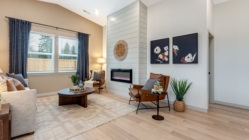 Great room with laminate flooring and an electric fireplace and vaulted ceilings