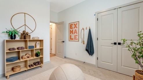 Bedroom staged as a home gym with wall-to-wall carpet and a closet