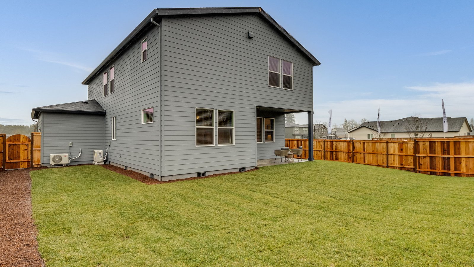fully fenced backyard with sod lawn and a patio