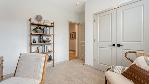 Bedroom staged as an office with wall-to-wall carpet and a closet