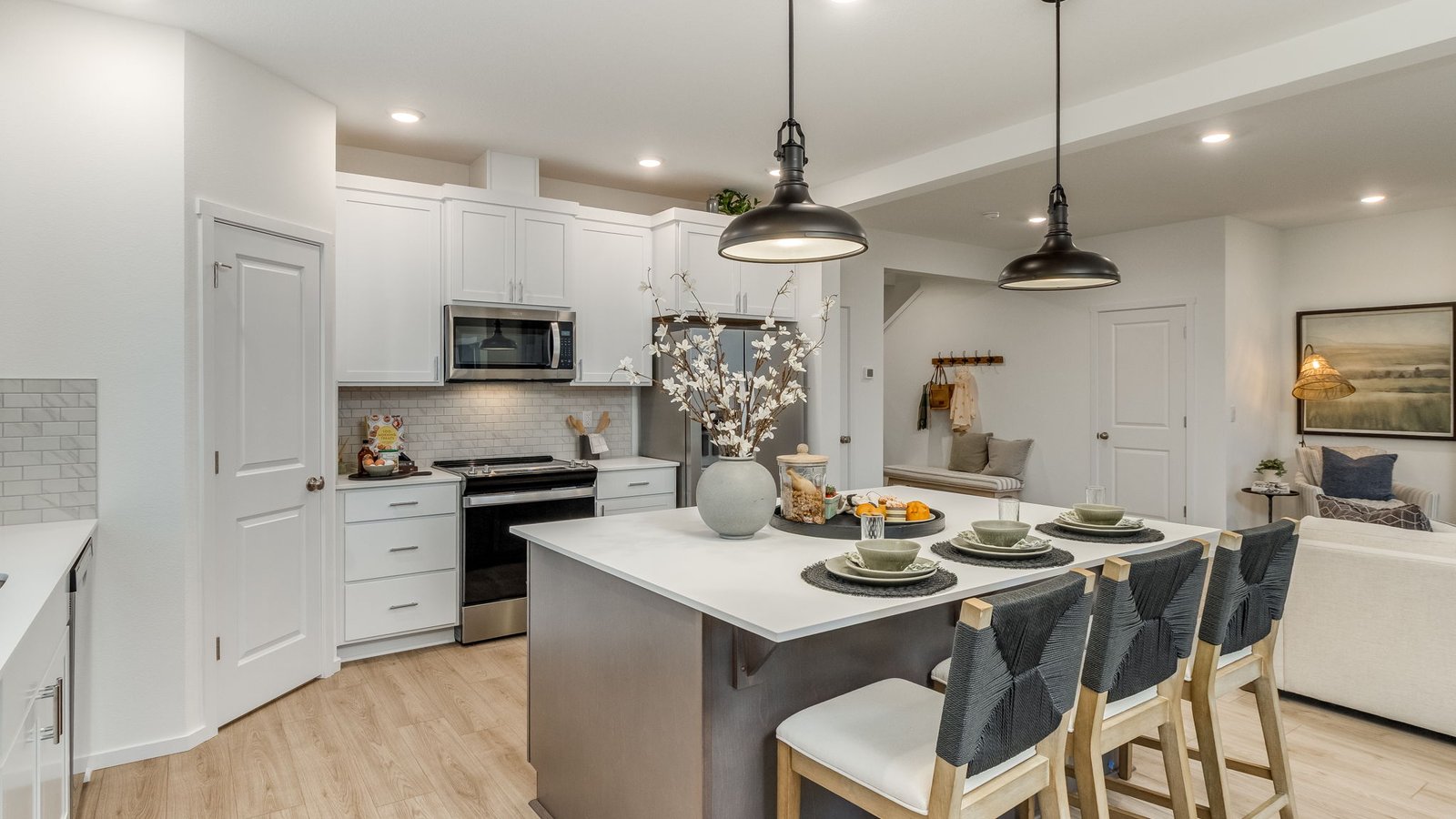 Kitchen with shaker cabinets, quartz counters, stainless steel appliances, pantry, and an island with a breakfast bar