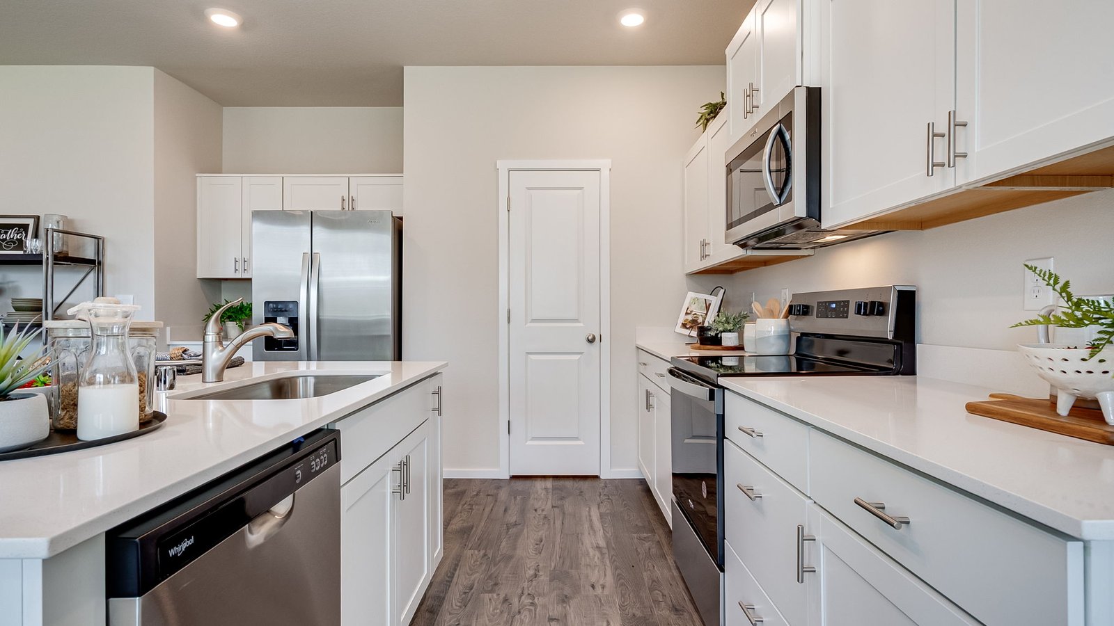 Kitchen with shaker cabinets, quartz counters, stainless steel appliances, pantry, and an island with a breakfast bar