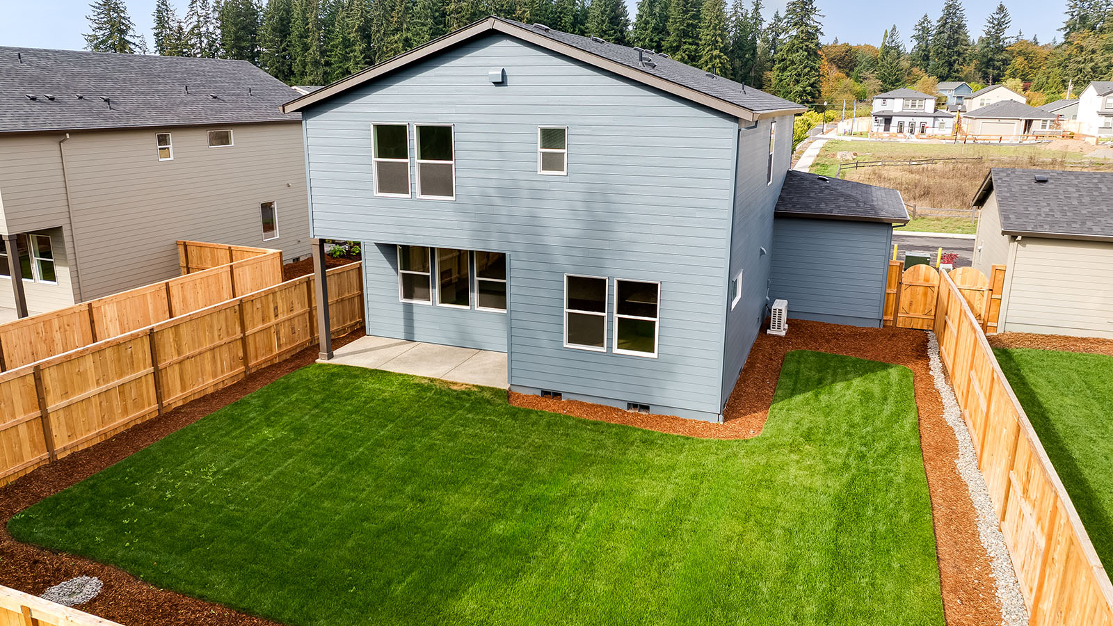 fully fenced backyard with sod lawn and a patio
