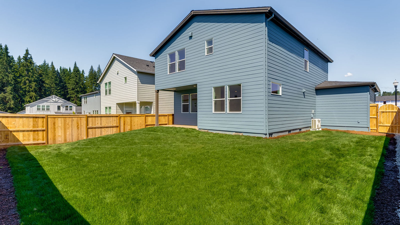 fully fenced backyard with sod lawn and a patio