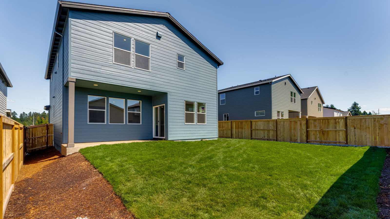 fully fenced backyard with sod lawn and a patio