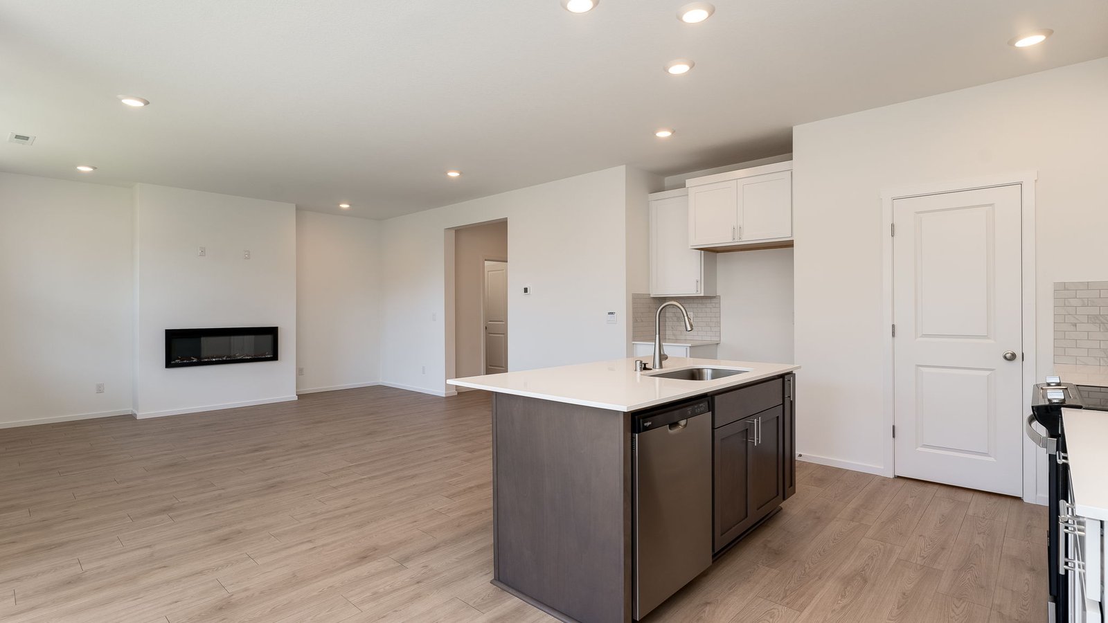 Kitchen with shaker cabinets, quartz counters, stainless steel appliances, pantry, and an island with a breakfast bar