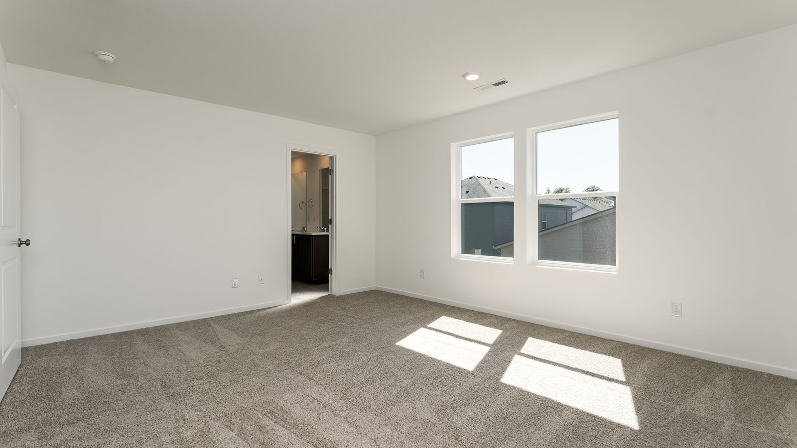Primary bedroom with wall-to-wall carpet, a walk-in closet and an attached bathroom