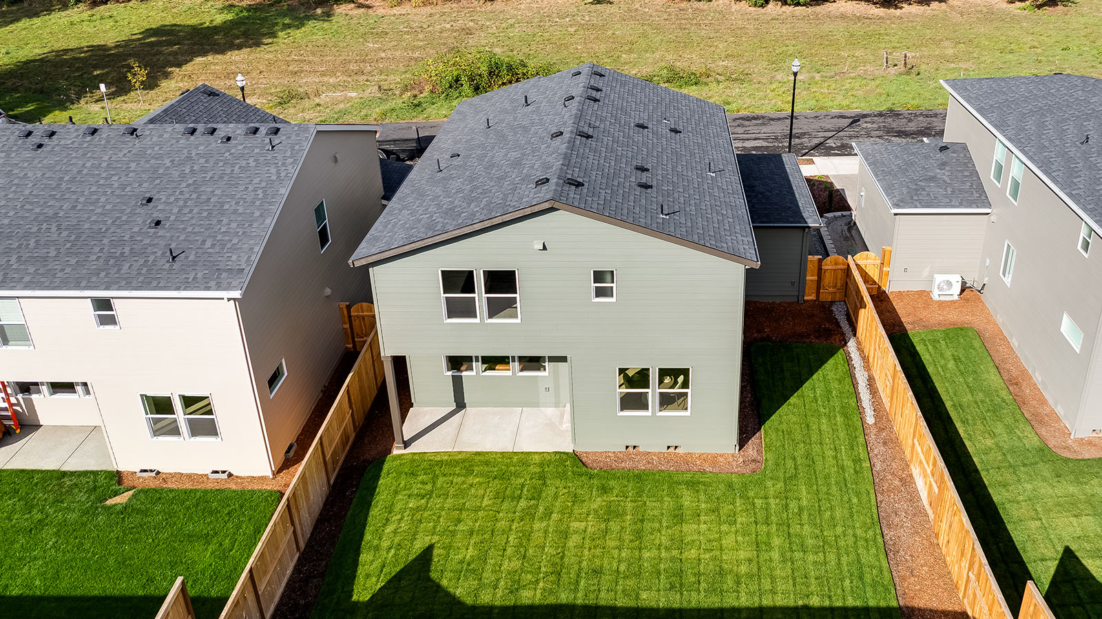 fully fenced backyard with sod lawn and a patio