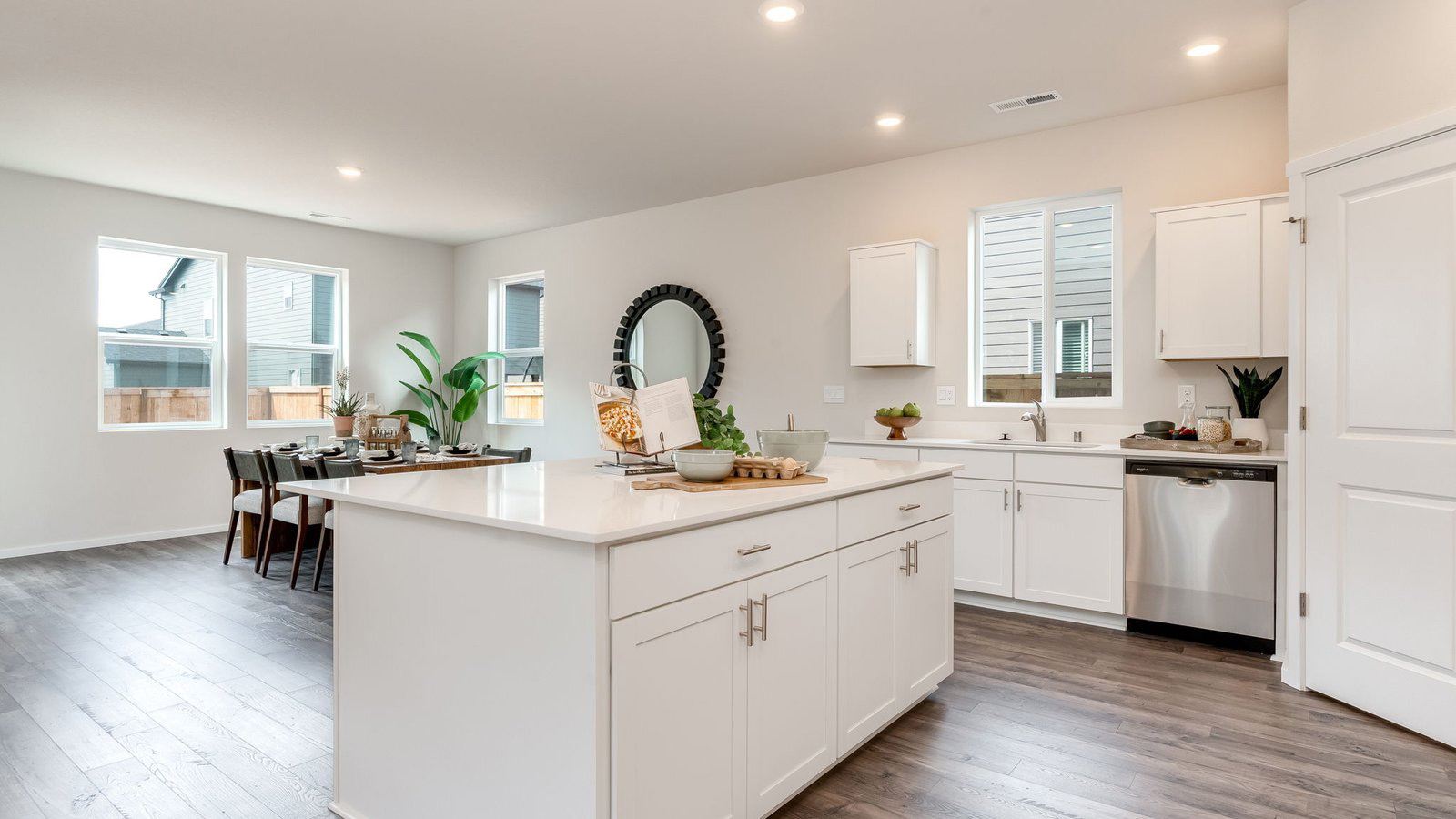 Kitchen with shaker cabinets, quartz counters, stainless steel appliances, pantry, and an island with a breakfast bar