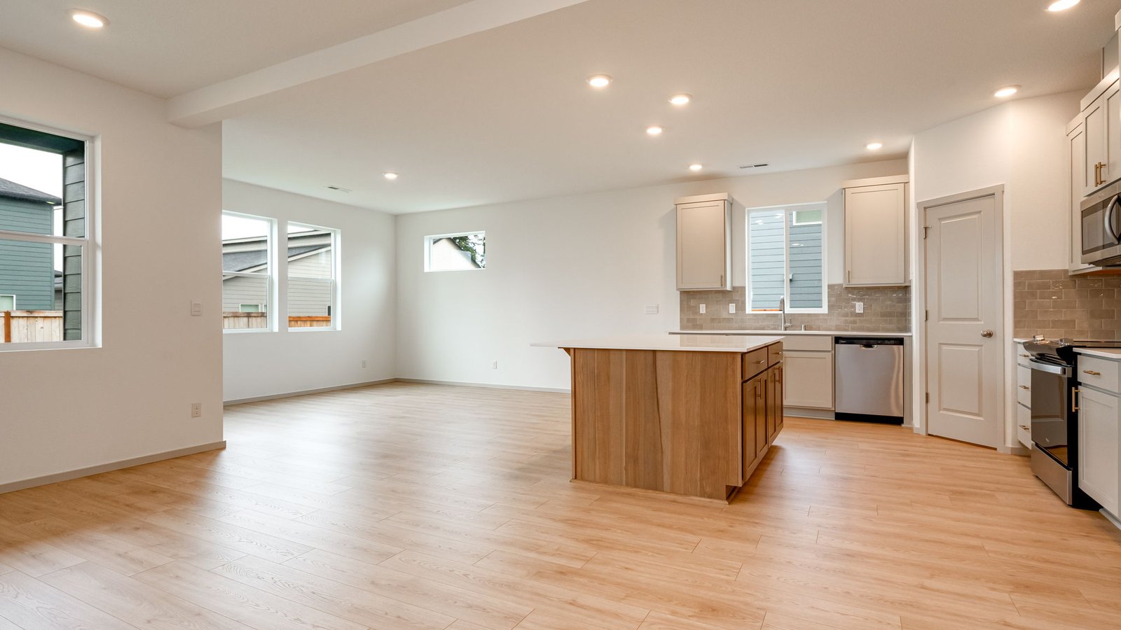 Kitchen with shaker cabinets, quartz counters, stainless steel appliances, pantry, and an island with a breakfast bar