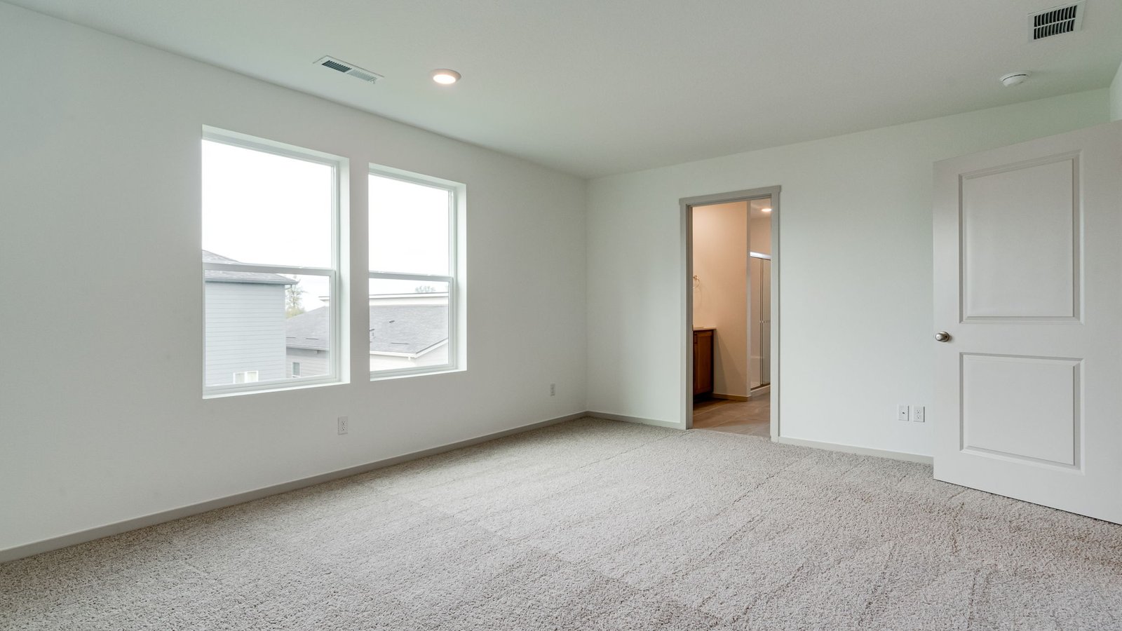 Primary bedroom with wall-to-wall carpet, a walk-in closet and an attached bathroom