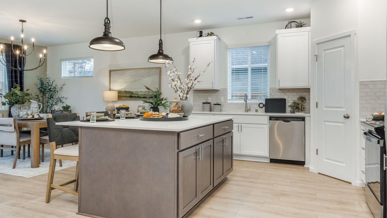 Kitchen with shaker cabinets, quartz counters, stainless steel appliances, pantry, and an island with a breakfast bar