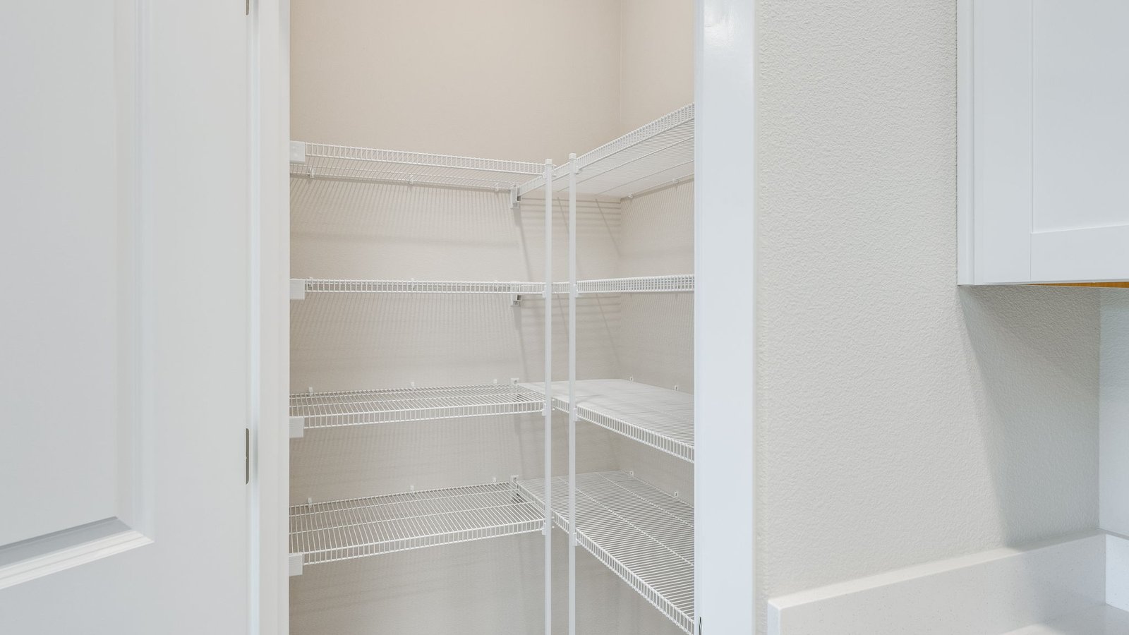 Kitchen with shaker cabinets, quartz counters, stainless steel appliances, pantry, and an island with a breakfast bar