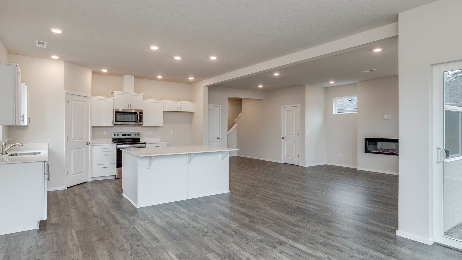 Kitchen with shaker cabinets, quartz counters, stainless steel appliances, pantry, and an island with a breakfast bar