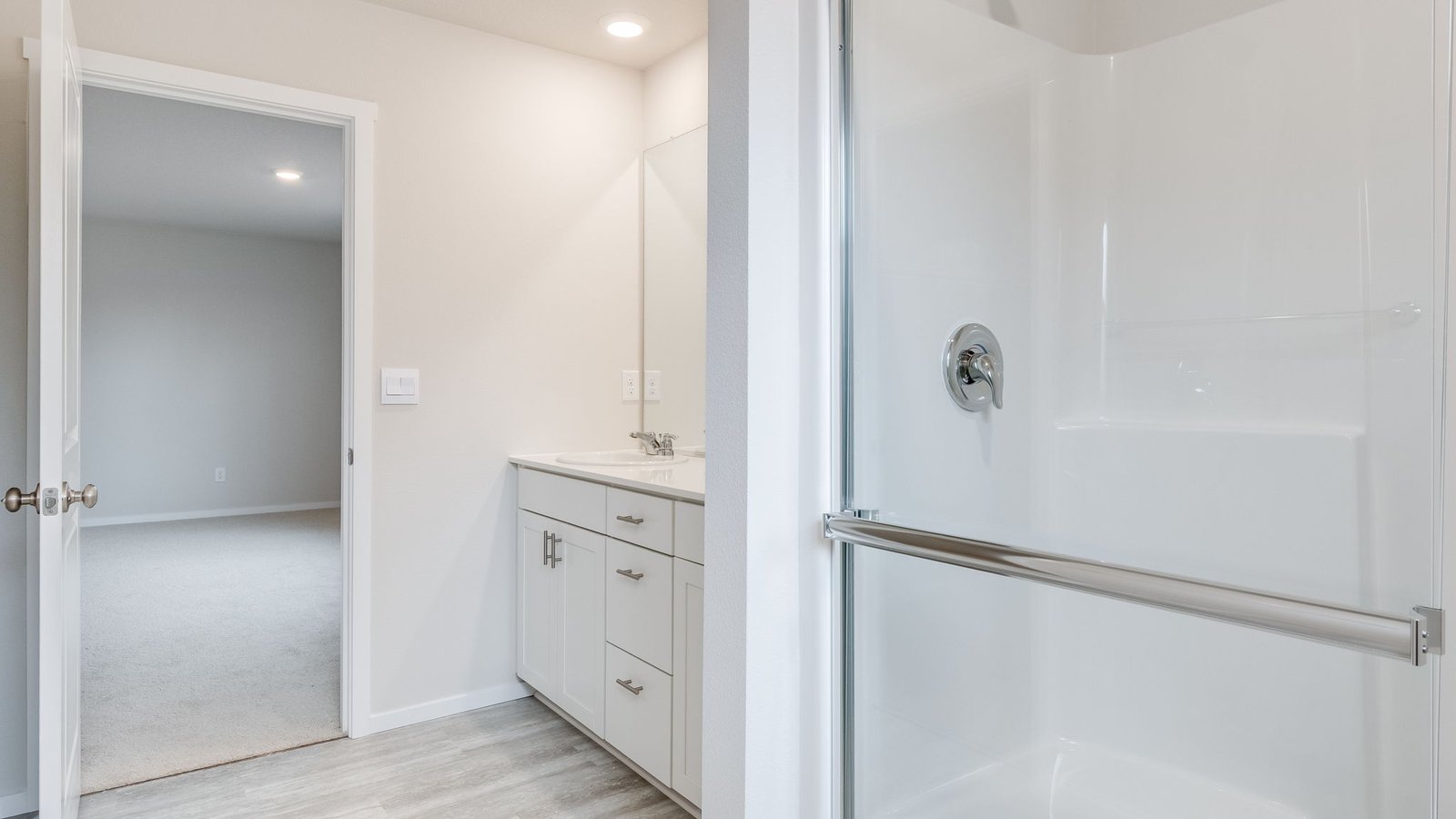 Primary bathroom with quartz counters and a walk-in shower