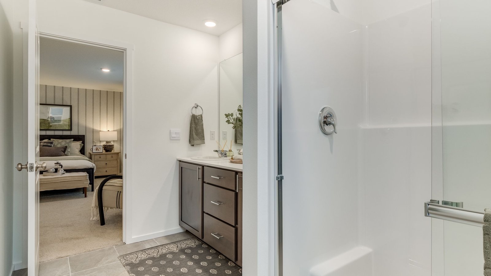 Primary bathroom with quartz counters and a walk-in shower