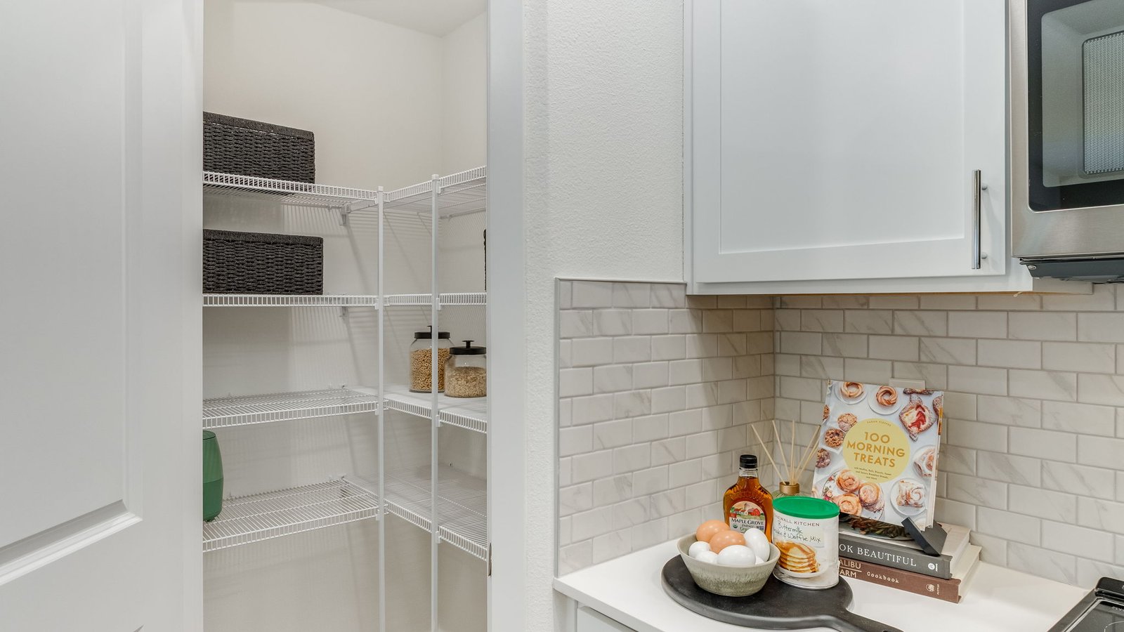 Kitchen with shaker cabinets, quartz counters, stainless steel appliances, pantry, and an island with a breakfast bar