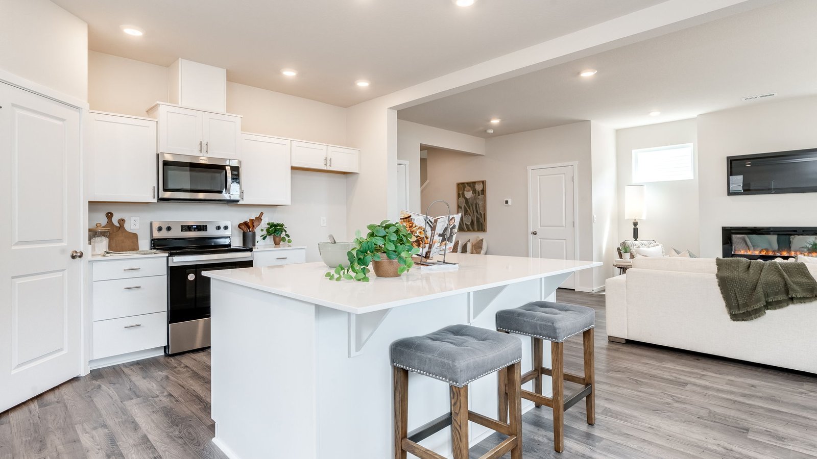 Kitchen with shaker cabinets, quartz counters, stainless steel appliances, pantry, and an island with a breakfast bar