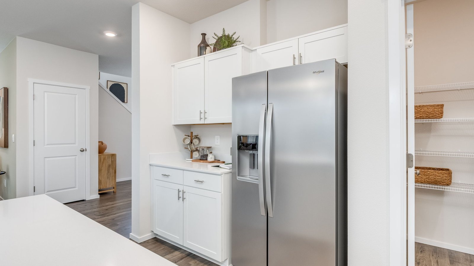Kitchen with shaker cabinets, quartz counters, stainless steel appliances, pantry, and an island with a breakfast bar
