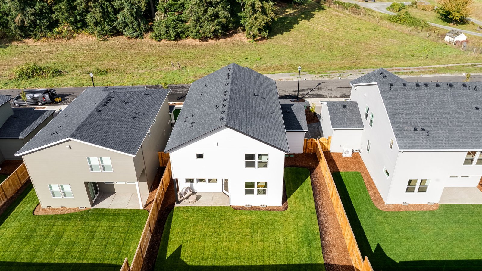 fully fenced backyard with sod lawn and a patio