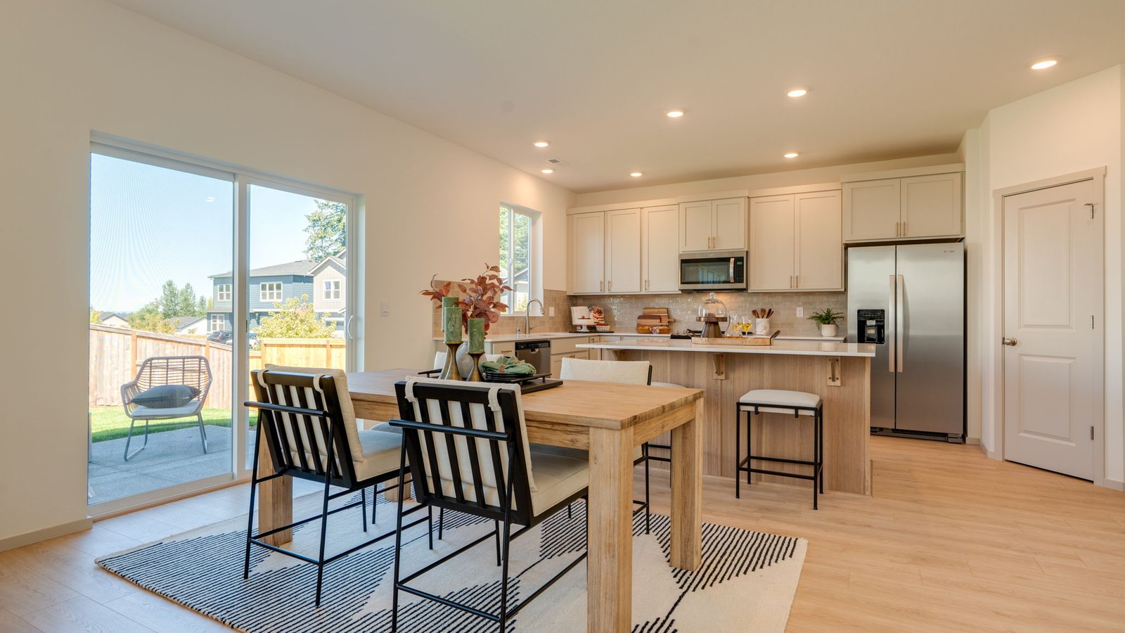 Kitchen with shaker cabinets, quartz counters, stainless steel appliances, pantry, and an island with a breakfast bar