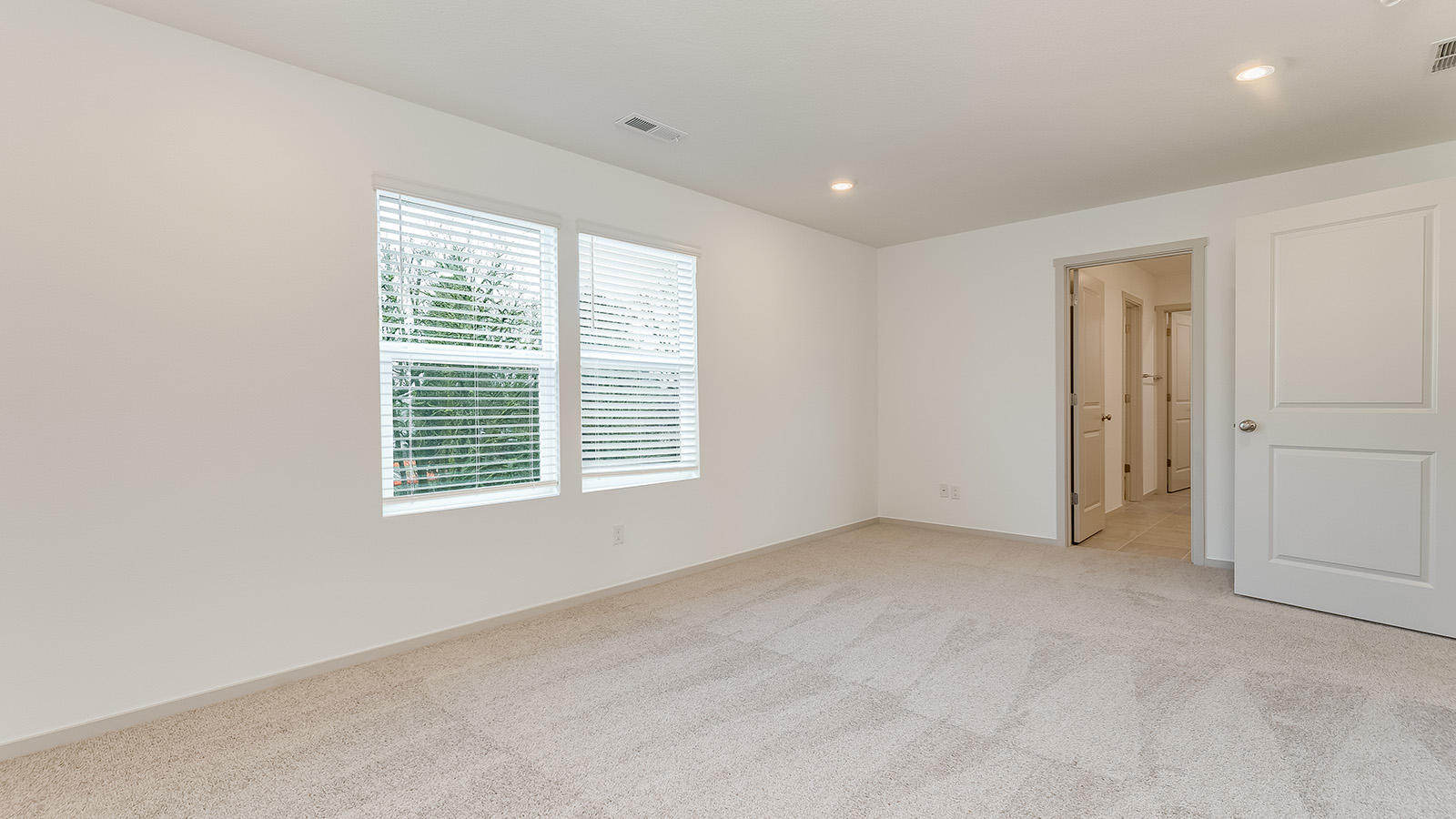 Primary bedroom with wall-to-wall carpet, a walk-in closet and an attached bathroom
